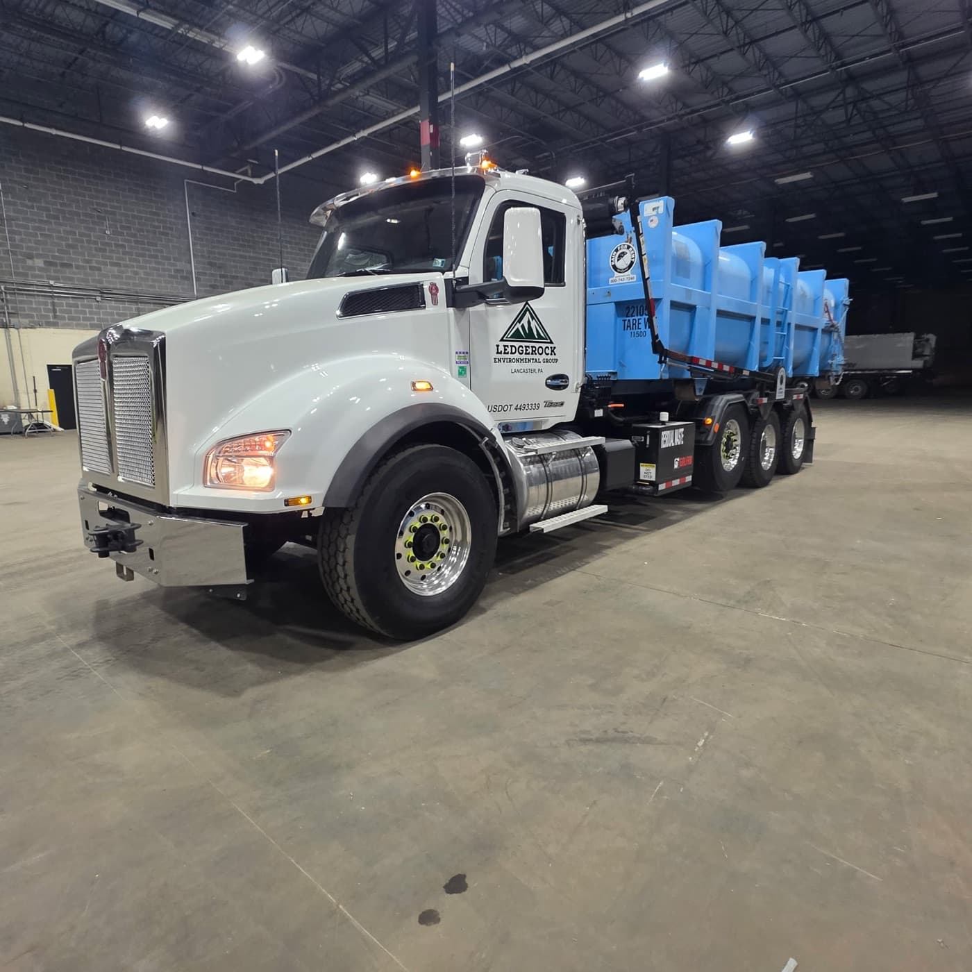 Ledgerock blue roll-off truck at warehouse facility